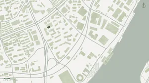 Aerial view of a city street intersection with various buildings, a green roof, and traffic lights