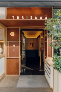 Welcoming restaurant entrance with a brown door, modern furniture, and well-lit interior