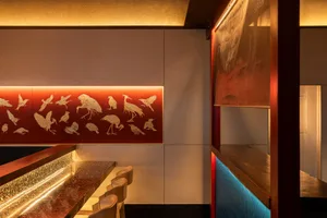 Inviting restaurant bar with a wooden countertop, chairs, and decorative birds on the wall