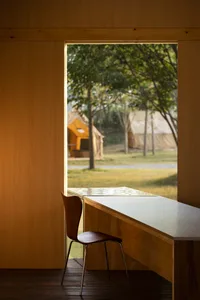 A study with a wooden desk and two chairs, featuring three tents for a temporary event or gathering
