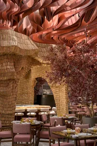 Warm and inviting restaurant interior with wooden walls and ceiling, multiple dining tables, and chairs