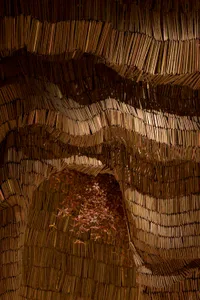 A three-dimensional book structure resembling a cave or tunnel, created from stacked books, with intricate arrangement and artistic design