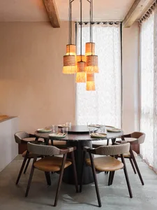 A round dining table surrounded by chairs, set for a meal, in a cozy and inviting room