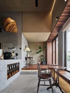 Modern restaurant dining area with two tables, chairs, and a potted plant, featuring a functional and inviting atmosphere