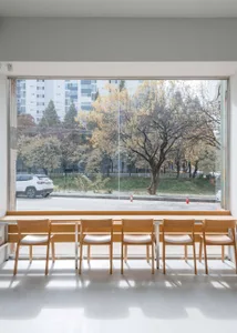 A cozy cafe interior with wooden chairs and a dining table, inviting atmosphere