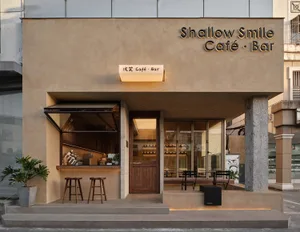 Spacious Asian restaurant with wood and concrete elements, comfortable seating, and potted plants