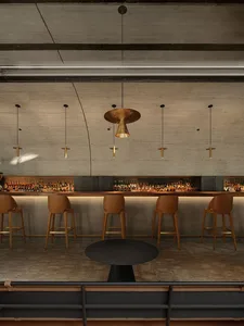 A cozy bar area with a long wooden counter and multiple chairs, creating a gathering spot for patrons
