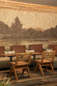 A warm and inviting dining area with a wooden table surrounded by multiple chairs and cushions