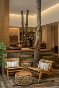 Cozy living area with wooden furniture, comfortable seating, and decorative elements, featuring a modern design with natural materials