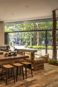 Warm and inviting restaurant interior with wooden floors and tables, featuring a countertop with various items and a cozy atmosphere