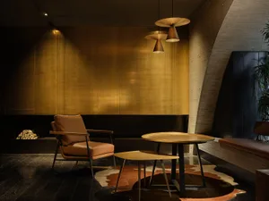 Cozy living space with a couch, chair, dining table, and TV, featuring a warm and inviting atmosphere