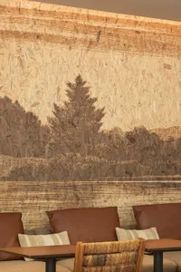 Warm and inviting living room with a tree in the center, featuring three chairs and a cozy atmosphere