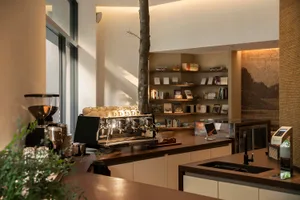 A warm and inviting kitchen with wooden cabinets and countertops, featuring a potted plant and scattered books, set in a well-designed space with a focus on functionality and aesthetics