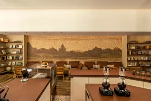 A cozy living area with a kitchen and dining room, featuring multiple couches, chairs, a coffee table, and various decorative items