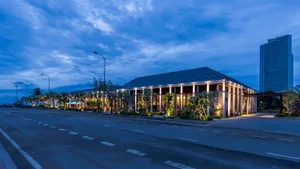 A modern building with several windows stands tall against the night sky, surrounded by potted plants adding to the calm ambiance