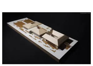 Architectural model of a modern museum with a wooden structure, showcasing a large open area with several rooms and hallways