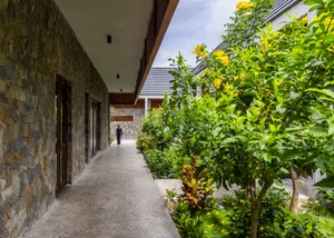 A house with a walkway leading to its entrance, featuring a patio area with potted plants and a pleasant atmosphere