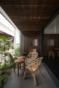 Cozy indoor space with a living area and dining area, featuring furniture, potted plants, and a warm atmosphere