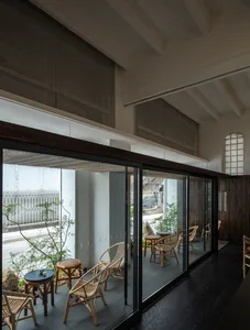現代餐廳內部，玻璃門通往露台區，融入木質元素，室內外座位區，悠閒氛圍