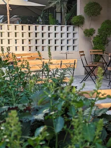 A patio area with wooden benches and chairs arranged in a comfortable and inviting layout, perfect for outdoor gatherings