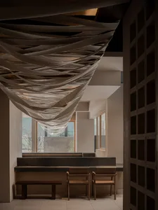 A modern restaurant kitchen with a wooden countertop, three chairs, and a functional design