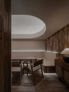 Warm and inviting living space with wooden floors and walls, featuring a dining table and two chairs