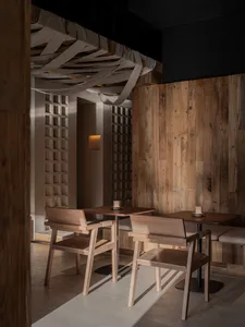 Warm and inviting restaurant interior with wooden floors and walls, featuring comfortable seating areas and dining tables