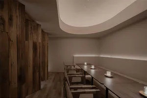 Cozy modern restaurant with wooden floors and walls, featuring dining tables with candles and chairs