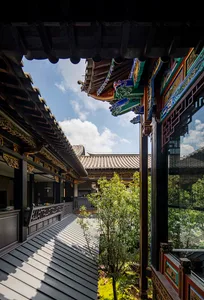 A real photo of an Asian-style building with a large roof and intricate details on its facade, featuring a courtyard surrounded by various structures with a mix of traditional and modern elements, natural light, and a sense of harmony between tradition and contemporary design