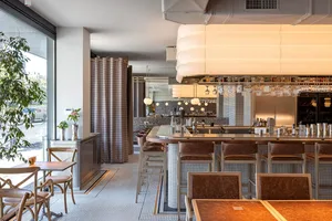 Inviting restaurant interior with a bar and dining tables, featuring bottles and comfortable seating