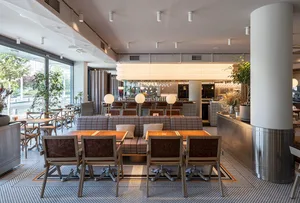 Open restaurant interior with modern design, wood and metal elements, lamps, and comfortable seating areas