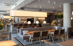 Cozy restaurant interior with modern furniture, wood flooring, and warm lighting creating a welcoming atmosphere