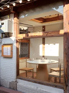 A cozy dining area with a large wooden table and several chairs, warm lighting, and comfortable seating arrangements