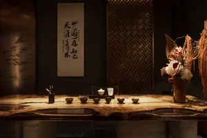 Elegant dining space with a wooden table, various bowls, cups, and spoons, creating a warm atmosphere