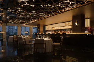 Cozy restaurant interior with a bar area, wooden elements, and dim lighting