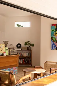 Cozy living space with a dining table, couch, coffee table, books, and a potted plant