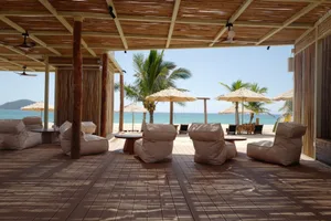 A relaxing beachside patio with chairs and umbrellas, surrounded by a scenic beach view