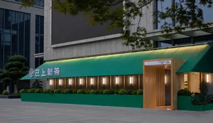 Modern Asian restaurant with green walls, a green roof, and potted plants around the entrance, creating an inviting and stylish atmosphere