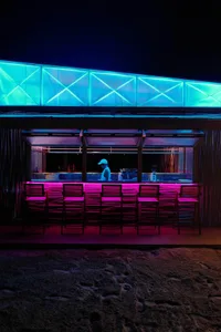 A well-lit bar area with a counter and multiple chairs for socializing and enjoying drinks