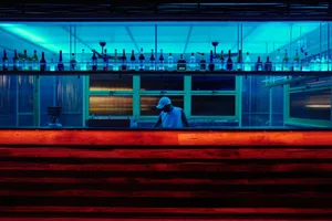 A casual bar scene with a wooden counter, bottles, and wine glasses, set in a welcoming atmosphere