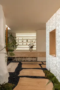 Well-lit interior design showroom with white walls, wooden floor, and decorative vases, creating a clean and modern atmosphere
