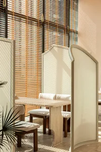 A well-lit dining area with multiple wooden tables and chairs, creating a warm and inviting atmosphere for social gatherings