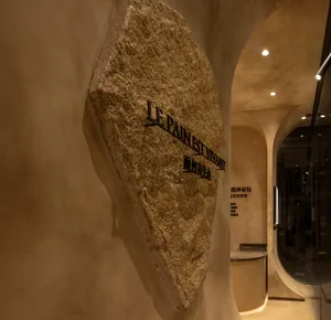 Modern showroom with a stone wall featuring a large embedded rock, well-lit and inviting