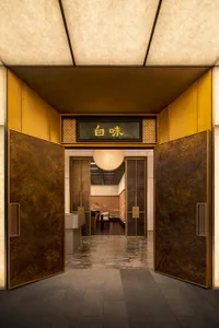 Elegant hallway with gold accents, brown walls, and well-lit space