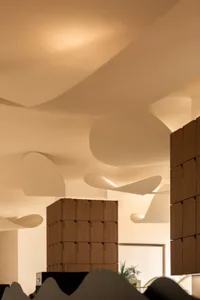 A modern building with white walls and wooden elements, showcasing a spacious and open interior and exterior space with bright daytime lighting