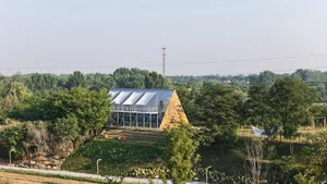 A modern building with a triangular shape and sloping roof, featuring a soft and diffused lighting, a chair, and an open space with a versatile atmosphere