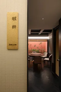 Cozy Asian restaurant interior with a wooden dining table surrounded by chairs and a potted plant, inviting guests to enjoy their meals