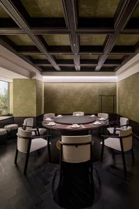 Empty modern dining area with a large wooden table and grey fabric chairs in a calm and inviting atmosphere
