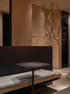 A modern living space with a wooden floor, featuring a black table, two couches, and a chair, with a focus on functionality and comfort