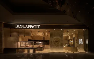 A well-lit restaurant interior with stone and wood walls, tables, and chairs, creating a warm and inviting atmosphere